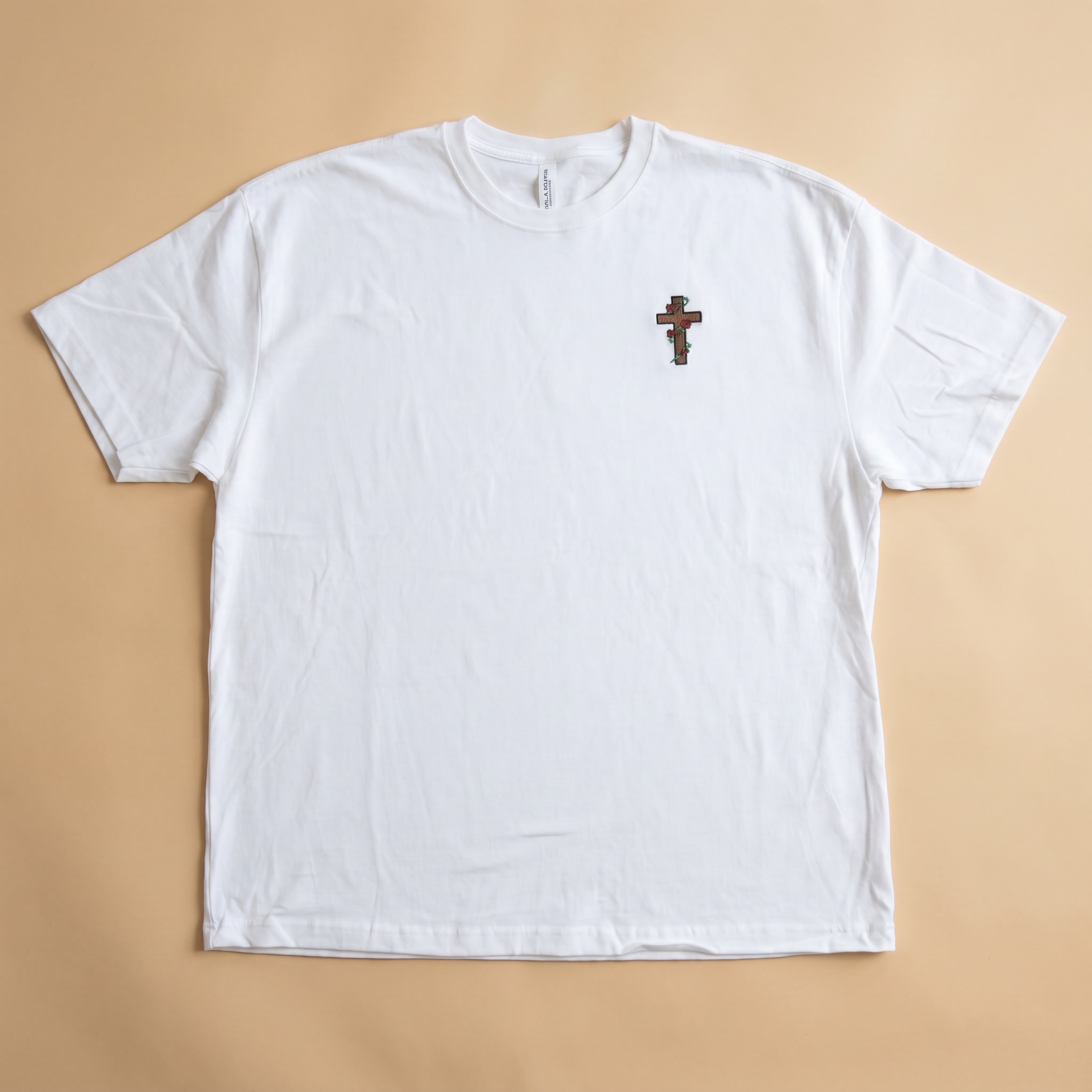 Cross Tee White front view, embroidered cross with thorned vines